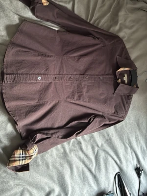 Burberry Skjorta - Bra skick, köptes ifrån plick och han sa att den var äkta så kan ej garantera äktheten. Väldigt liten i storlek. Hade sagt vid cirka  XS. Skriv vid frågor