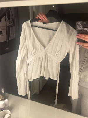 Vit topp med v-ringning - Säljer denna super fina toppen i mycket bra skick!