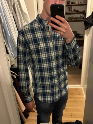 Blåvit rutig skjorta från Polo Ralph Lauren - Säljer en klassisk blå och vit rutig / randig skjorta från Polo Ralph Lauren. Mycket bra skick, inga tecken på användning.