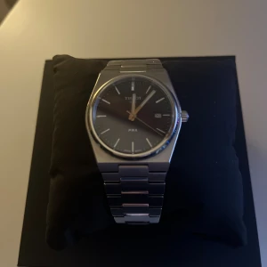 Tissot PRX 40mm - Bilderna visar en Tissot PRX klocka i originalförpackning. 40mm med extra länkar. Är i rätt bra skick syns på armbandet att det är använt men är fortfarande sjukt snygg och stilig. Batteriet är 1 år gammalt. 
