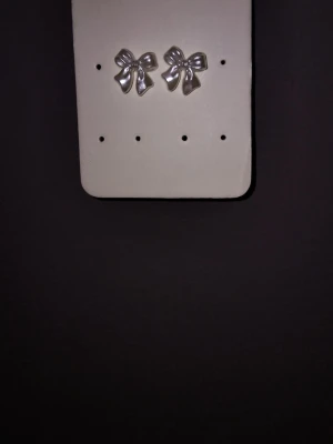  Rosett örhängen  - Bilderna visar ett par vitta rosettörhängen från Lovisa