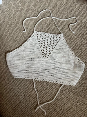 Vit virkad linnetopp från BikBok - Supersöt virkad linnetopp från BikBok i vitt. Toppen har knytband i nacken och ryggen, samt ett snyggt hålmönster upptill som ger en boho-vibe. Perfekt till sommaren och lätt att matcha med jeans eller kjol.