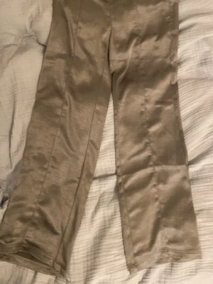 Silvriga vida byxor från Gina Tricot - Silvriga byxor, gömd dragkedja på sidan.  //skriv om ni undrar om något 💕(läs min profil)