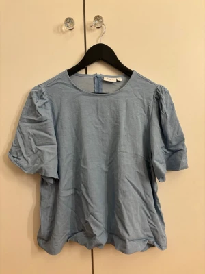 Ljusblå blus från Saint Tropez - Säljer en ljusblå blus från Saint Tropez i storlek S. Blusen har puffiga korta ärmar och rund halsringning. Stängs med dragkedja bak. Tillverkad i mjuk bomull. Den stryks så klart om någon vill köpa den!🤗inte använd! 