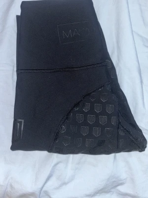 Svarta ridleggings från Maya Delorez - Säljer ett par svarta ridleggings från Maya Delorez med hög midja och silikonmönster längs insidan av benen för extra grepp. Stretchigt och bekvämt material som passar perfekt till ridning. Diskret logga på benet och stilren design.