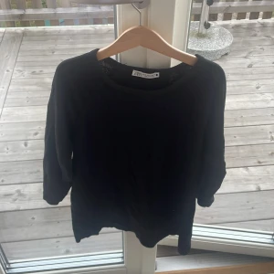 Svart tröja från Zara - En svart tröja från Zara i enkel och stilren design. ärmarna är lite kortare och Tröjan har rund halsringning och är tillverkad i mjukt bomullsmaterial, perfekt för lager-på-lager eller chill dagar. Passar dig som gillar basic men snygg stil. 