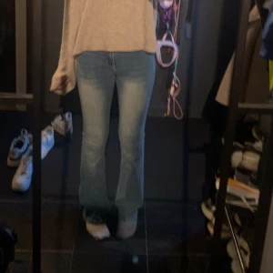 Blå bootcut jeans med broderade fickor - Snygga ljusblå bootcut jeans med coola broderade detaljer på bakfickorna och slitningar för en trendig look. Jeansen har klassisk femficksdesign och sitter tajt upptill med utsvängda ben. Perfekta för dig som gillar en avslappnad men ändå stilsäker vibe.