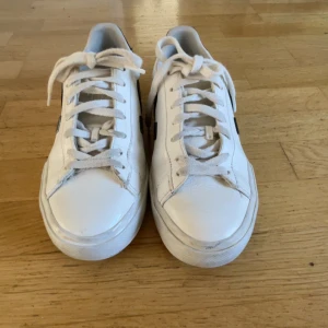 Vita Veja sneakers med svart detalj - Säljer ett par klassiska Veja sneakers i vitt skinn med svarta detaljer på sidorna och hälen. Skorna har rund tå, platt sula och snörning framtill. Perfekta för dig som gillar stilrena och trendiga sneakers med en clean look.