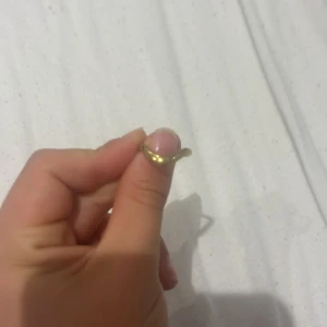 Guldfärgad böjd ring - Snygg guldfärgad ring med böjd form som ger en cool och unik look. Perfekt för dig som gillar minimalistiska smycken med en twist. Ringen är enkel men sticker ut med sin mjuka kurva och glänsande finish.