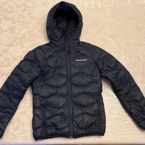 Säljer Marinblå Peak Performance Höst/Vår Jacka! - Storlek: XS Jackan fungerar att ha på sig både under hösten och våren.  Jackan har ett litet hål som är sydd. Hålet syns knappt ni kan kolla på sista bilden, har lagt till en röd cirkel så att ni ser vart hålet är. 