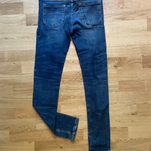 Mörkblå skinny jeans från Dondup - Snygga mörkblå skinny jeans från dondup  med slitningar på knät. metallogo på bakfickan. Fin kvalloetet och sparsamt använt 