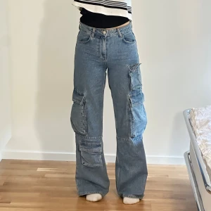 Blå cargojeans  - Säljer ett par snygga blå cargojeans från Bershka, väldigt bra skick! Storlek XS