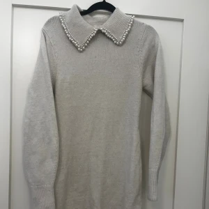 Beige stickad klänning från H&M - Supersöt beige stickad klänning från H&M med en krage dekorerad med pärlor. Storleken xs