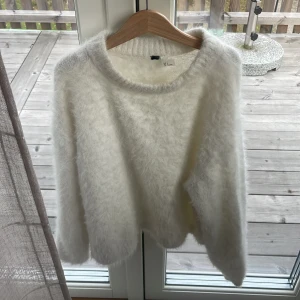 Fluffig vit stickad tröja S - Supermjuk och fluffig vit stickad tröja från H&M i storlek S. Tröjan har rund halsringning och långa ärmar, perfekt för kyliga dagar. 