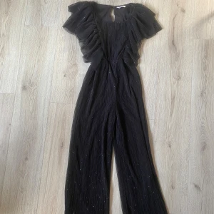 Svart glittrig byxdress med volanger - Säljer en svart byxdress med glittriga detaljer ❤️nypris ungefär 300kr från Cubus 🎀🤍