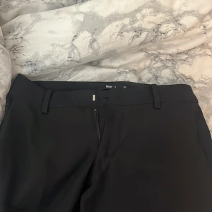 Svarta kostymbyxor från BikBok Petite - Snygga svarta kostymbyxor från BikBok i storlek 34 petite. Jag är 159cm och dom går till mina hälar. Byxorna har raka ben, bälteshällor och dragkedja framtill. Perfekta för en clean och stilren look. Materialet känns mjukt och följsamt. Pris kan diskuteras 