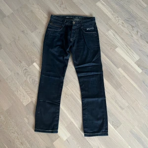 Svarta jeans från Jack & Jones - Svarta jeans från Jack & Jones med klassisk femficksdesign och kontrastsömmar. Byxorna har dragkedja på myntfickan och broderad logga på fickan fram. Snygg rak passform och tillverkade i mjukt jeanstyg. OBS! (Inner längd 67cm)