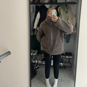 Brun teddyjacka HM  - Ljusbrun teddyjacka med hög krage och stora fickor framtill. Från HM i storlek S. Köpt förra hösten, i mycket bra skick. 