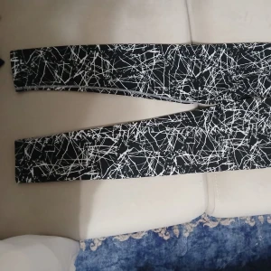 Svarta leggings med vitt mönster U.WE.AR - Snygga svarta leggings från U.WE.AR i storlek S med ett coolt vitt abstrakt mönster över hela byxan. Stretchigt material som sitter tight och bekvämt, perfekt för träning😃