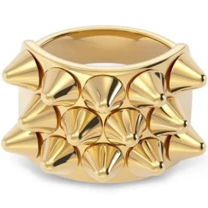 Guldig ring med nitar - Cool och chunky ring i guld med flera spetsiga nitar framtill. Ringen har en bred design och ger en edgy vibe, perfekt för dig som vill sticka ut med accessoarerna. Metallfinishen är blank och fångar verkligen blicken. Helt ny 