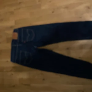 Levi's 501 CT mörkblå jeans 30/32 - Mörkblå Levi's 501 CT jeans med klassisk femficksdesign och raka ben. Snygga kontrastsömmar och ikonisk läderpatch bak i midjan. Perfekta för dig som gillar tidlös denimstil och vill ha ett par jeans som funkar till allt.