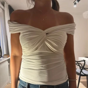 Offshoulder fest topp💓 - Säljer en snygg offshoulder topp i vit färg med twistad detalj framtill. Toppen är perfekt för fest men kan även användas till vardag om man vill klä ner den. Super fint skick!🫶🏼