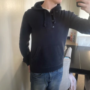 Blå unik stickad hoodie - Riktigt fet stickad blå hoodie med knappar. Perfekt till kallare väder. Modellen är 180cm, 73kg. Priset går att diskutera!
