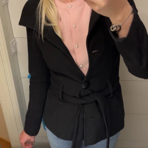Svart kappa från vero moda - INTE MIN BILD! Säljer min svarta kappa med knytning (nypris 699kr). Köpte den begagnat men jag har aldrig använt den då den var för liten, endast testad. Väldigt fin men för liten för mig som sagt. Tvättar och nopprar innan jag skickar iväg den.😇🌸
