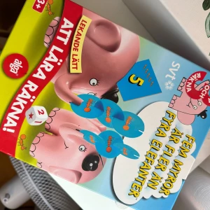 Fem myror är fler än fyra elefanter: Elefantens räknespel - Ett roligt och pedagogiskt räknespel inspirerat av 'Fem myror är fler än fyra elefanter'. Perfekt för dig som vill lära dig räkna på ett lekfullt sätt! Passar från 3 år och uppåt. Utmana vänner och se vem som kan balansera flest myror på elefanten snabbast. Fint i skick, lite smått slitet men annars superbra! Komplett!