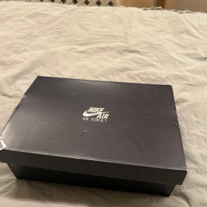 Nike Air Force 1 beige high sneakers - Säljer ett par Nike Air Force 1 high sneakers i beige läder med grov sula och snörning. Skorna har en metallspänne vid ankeln och klassisk Nike-logga på sidan. Snygg och clean look med ljus gummisula som ger extra edge till outfiten. NYPRIS 699kr