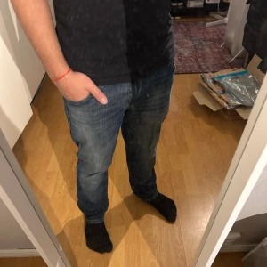  jeans från Jack & Jones - Snygga mörkblå jeans från Jack & Jones med klassisk femficksdesign och diskret slitning framtill och baktill. Jeansen har raka ben och normal passform, perfekt för en avslappnad stil. Tillverkade i mjukt denimtyg för skön känsla hela dagen.