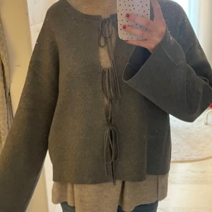 Grå kofta med snörning - Mysig grå kofta med breda ärmar och snygg snörning framtill. Koftan har en loose passform och är perfekt att slänga över en polotröja. Materialet känns mjukt och passar bra till lager-på-lager-stil. SKRIV FÖR FLER BILDER!!