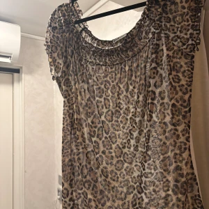 Leopardmönstrad topp fr Gina Tricot - Säljer en luftig och snygg leopardmönstrad top från Gina Tricot. Toppen har korta ärmar med volangdetaljer och en rundad, rynkad halsringning. Perfekt för dig som vill sticka ut med ett djurmönster.