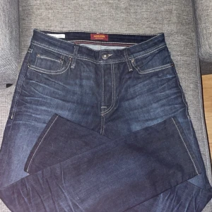 Jack and jones jeans, så gott som nya  - 🧵 Titel: Jack & Jones jeans – Regular/clark/slim fit, mörkblå denim, som nya  📄 Beskrivning: Snygga mörkblå jeans från Jack & Jones i slim fit-modell. Nästan helt nya – endast provade ett fåtal gånger. Väldigt bra passform och stretchigt material som sitter perfekt utan att kännas tighta. Inga fläckar, hål eller slitage.  Perfekta vardagsjeans med klassisk stil som funkar till allt!     Pris: 349kr (kan ev. diskuteras)  Storlek: [29/32 Skick: Som nya.  #Hashtaggar: #jackandjones #jeans #de