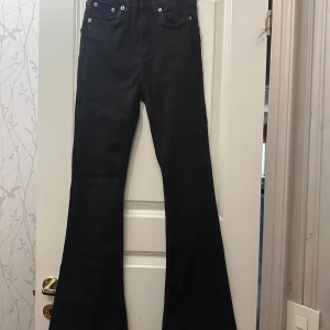 Svarta flare jeans från lager 157 - Svarta jeans från lager 157 med modellen Snake Flare. Byxorna har klassisk femficksdesign, hög midja och  utsvängda ben. Materialet är jeans och färgen är svart.