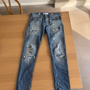 Slimfit replay med slitningar - Säljer ett par blå jeans från Replay i slim fit och snygga slitningar framtill och på bakfickorna. Jeansen är i mycket bra skick. W29 L34 längd: 101cm.   Pris: 349💰