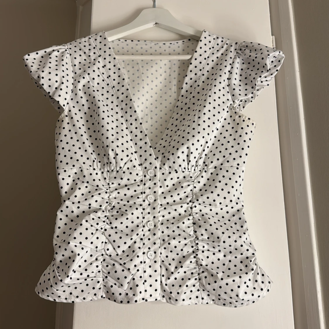 Vit prickig blus med v-ringning