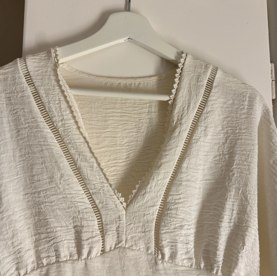 Vit blus med v-ringning och spetsdetaljer - 1