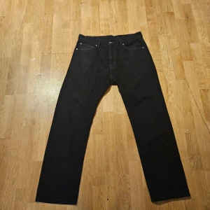 Svarta Levi's 505 jeans W33 L30 - Svarta Levi's 505 jeans med klassisk femficksdesign och raka ben. Jeansen har en normal passform och är tillverkade i slitstarkt jeanstyg. Perfekt för dig som gillar tidlös stil och vill ha ett par jeans som funkar till allt.