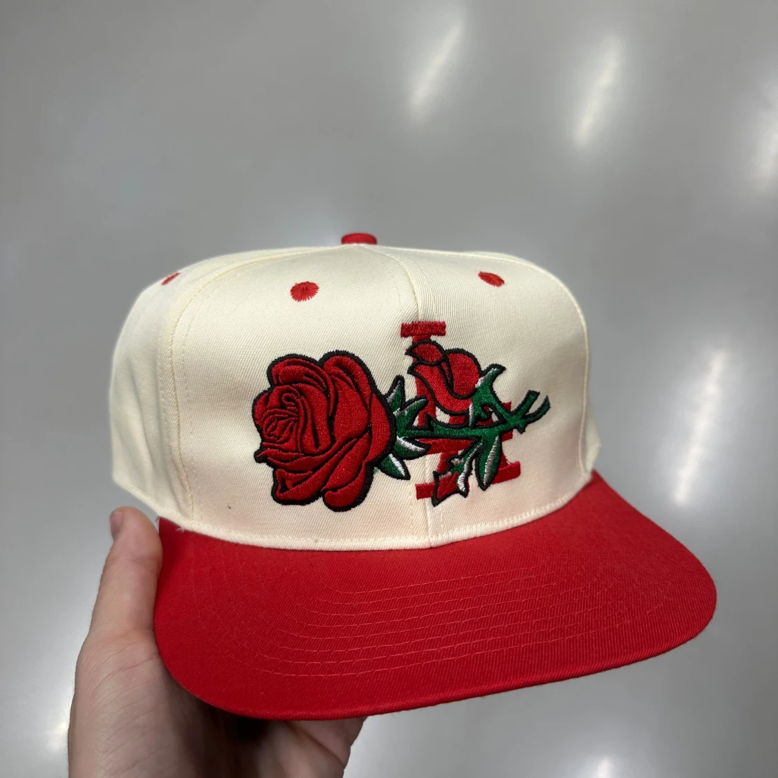 Röd och vit keps med rosbroderi