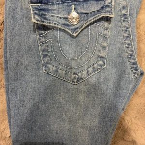 True Religion Joey ljusblå jeans - Säljer ett par ljusblå True Religion Joey jeans med låg midja och klassisk fickdesign med silverfärgade knappar. Jeansen är flsre, helt nya säljer för att dem är för långa. Ny pris 1399