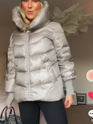 pufferjacka med stor krage - Säljer en silvrig/champagne/rosa pufferjacka med stor, fluffig krage och dragkedja framtill. Jackan har långärmade ribbade muddar och en cool, quiltad look som ger extra volym. Perfekt för dig som gillar streetstyle och vill sticka ut med metallic-vibe. Det är samma jacka på alla bilder bara ljuset som är olika! Sista bilden är min💓💓