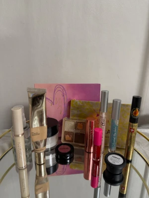 Sminkpaket med paletter och läppglans - Stort sminkpaket med Jeffree Star ögonskuggspalett i rosa och gult, Miss Rose foundation i beige tub, Yabailian ögonskuggspalett med bruna och nude toner, IsaDora rouge i rosa, Technic läppglans i rosa och korall, concealer, mascara, eyeliner och transparent puder. Perfekt för dig som älskar att experimentera med olika looks.