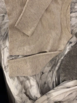 Beige stickad tröja från Gina Tricot - Mysig beige stickad tröja från Gina Tricot med rund halsringning och breda ribbade muddar vid ärmslut och nederkant. Perfekt för lager-på-lager och chill dagar. Enkel och stilren design som funkar till det mesta.