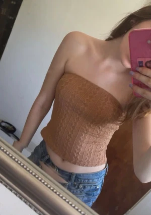 Brun stickad tubtopp från SHEIN  - Supersnygg brun stickad tubtopp från SHEIN i storlek XS. Toppen har ett coolt mönster med stickade detaljer och är axelbandslös för en trendig look. Materialet är mjukt och stretchigt, 99% polyester och 1% elastan. Perfekt att matcha med jeans eller kjol!