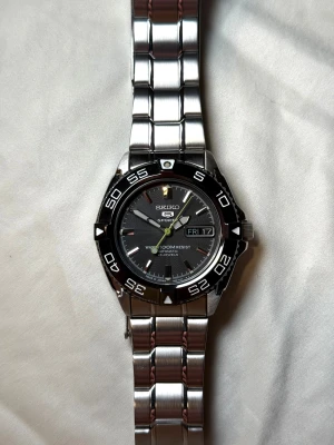 Seiko 5 Sport SNZB23J1 - Aldrig använd 39mm - Seiko 5 Sport SNZB23J1 i perfekt nytt skick, köptes för bara ett par månader sen ny och har bara används ett några gånger. Ny pris ligger på 4600kr.  Orginalboxen, extra länkar, instruktionsbok, certifikat och orginalpåsen den köptes i medföljer vid köp. Det är bara om skriva om du har några funderingar!