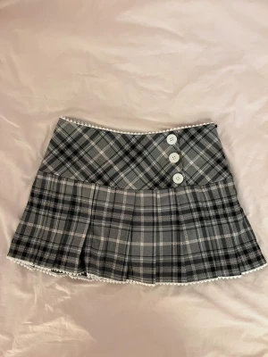 Cherie Lou Kjol - Super söt gullig Cherie Lou kjol med plaid mönster. Använd enbart en gång, prislapp sitter kvar.  Liten i storlek så skulle säga att den passar mer nån som är storlek S än storlek M. Cherie Lou är ett litet sustainable fashion brand ifrån Kina. Kjolen kommer med inbyggda shorts.