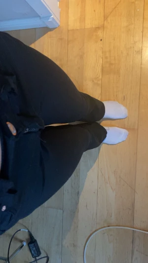 Svarta bootcut jeans med dragkedja - Säljer ett par svarta jeans med bootcut-snitt och klassisk dragkedja framtill. Byxorna har en smickrande passform med normal midja och raka ben som breddas vid ankeln. Perfekta för dig som gillar stilrena och tidlösa jeans.