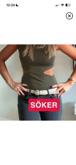 Olivgrön croppad linnetopp med cut-outs - Trendig olivgrön ärmlös linnetopp med coola cut-outs i midjan. Toppen har en tight passform och hög hals, perfekt för att sticka ut. Materialet ser ut att vara mjukt och stretchigt, vilket gör den bekväm att bära till jeans eller kjol.