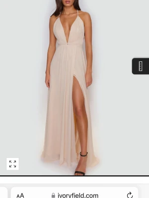 Ljusrosa Champagnefärgad balklänning  med djup v-ringning - Säljer en elegant champagnefärgad lite ljusrosa  långklänning från Ivoryfield i luftig chiffong. Klänningen har djup v-ringning, tunna axelband och en snygg slits  framtill. Jag hade den på min bal och har ingen mer användning ut av den så därför säljer jag den. Skriv för fler bilder 😊